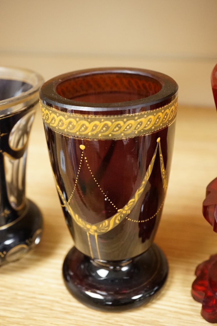 A 19th century Bohemian engraved ruby glass goblet, a similar amethyst and clear overlaid glass vase and an enamelled amethyst glass goblet, largest 15cm high